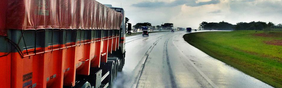 Imagem mostra a lateral de um caminhão andando na estrada